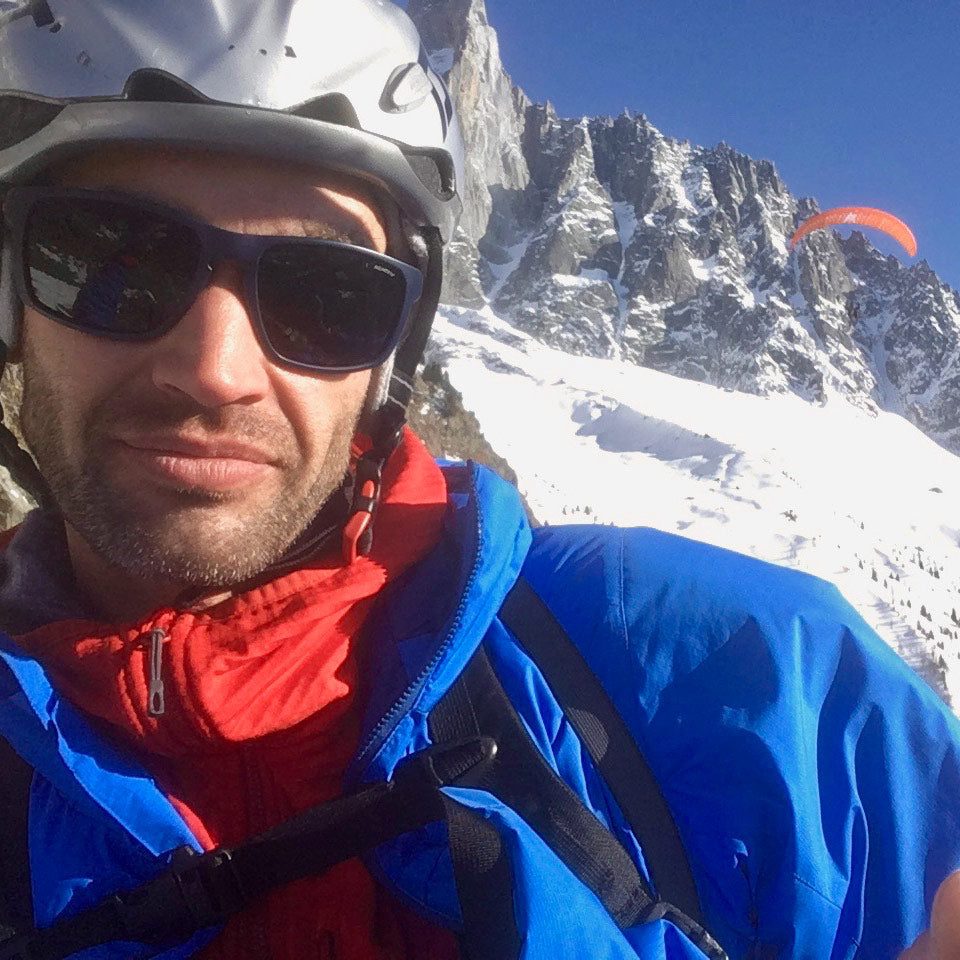 Chris Warner paragliding in Chamonix. Wearing Grid Pro Hoodie underneath Guide PrimaLoft Hoodie